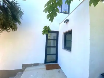 a white building with a blue door on it at Pandi's Place in Sant Pere de Ribes