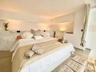 a white bedroom with a large white bed with pillows at Pandi's Place in Sant Pere de Ribes