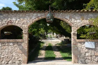 an archway in a stone wall with a bird cage at El Recer in Sant Pau dʼOrdal