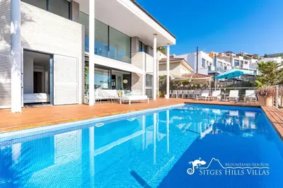 a swimming pool in front of a house at Super Villa Oasis Fab Sea and Sitges View with Private Pool and Air Conditioning in Sitges