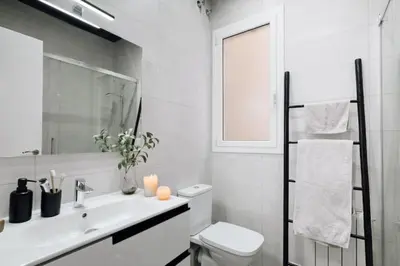 a bedroom with a chair and a window at Bari - 2 bedroom and office in Sant Antoni in Barcelona