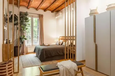 a bedroom with a bed and a clock on the wall at Kakwa - 2 bedroom and balcony Eixample Esquerra in Barcelona