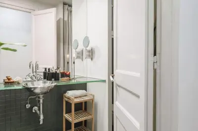 a living room with a black shelf with a plant on it at Kakwa - 2 bedroom and balcony Eixample Esquerra in Barcelona