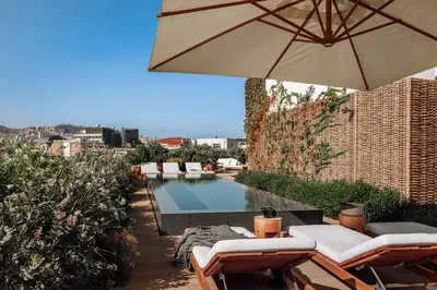 a pool with chairs and an umbrella and a swimming pool at Bemba - 1 bedroom and swimming pool in Passeig de Gracia in Barcelona