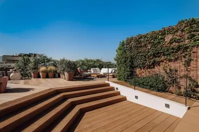 a patio with wooden steps and a brick wall at Kele - 1 bedroom and swimming pool in Passeig de Gracia in Barcelona