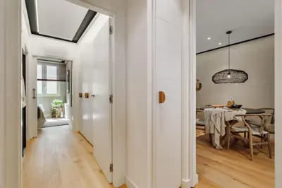 a kitchen with white cabinets and a bar with stools at Lega - 2 bedroom in Passeig de Gracia in Barcelona