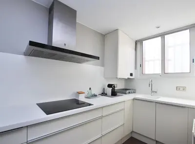 a white kitchen with white cabinets and a sink at Rey apartment in Vilassar de Mar