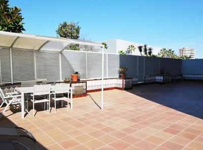 a patio with a table and chairs and a fence at Rey apartment in Vilassar de Mar