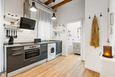 a kitchen with a stove and a washer and dryer at Lodging Apartments Almirall Beach 11 in Barcelona