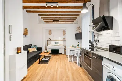a kitchen and living room with a bed in a room at Lodging Apartments Almirall Beach 11 in Barcelona