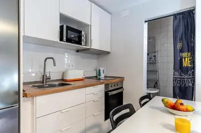 a kitchen with white cabinets and a table with a bowl of fruit at 2124 - AB Poblenou Beach Comfort in Barcelona