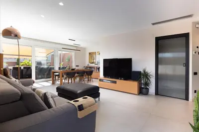 a living room with a couch and a television at Villa Beach Barcelona in Montgat