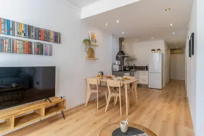a kitchen and living room with a table and a television at 1774 - AB Saint Joseph Apartment in Barcelona