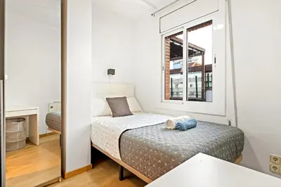 a small bedroom with a bed and a window at Precioso Atico Vistas Montjuic in Barcelona