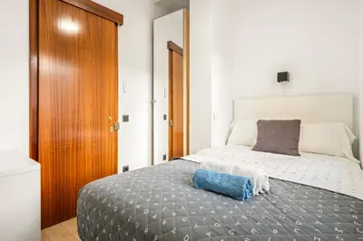 a bedroom with a large bed with a wooden door at Precioso Atico Vistas Montjuic in Barcelona