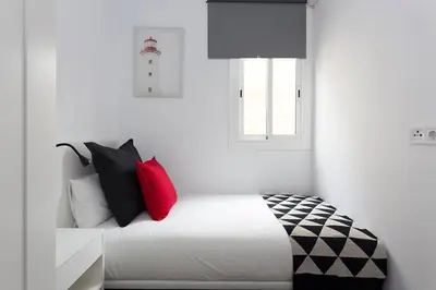 a bedroom with a bed with red and black pillows at Cozy And Quiet In Trendy Sants in Barcelona