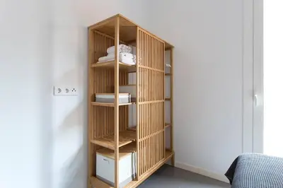 a wooden book shelf in a room at Cozy And Quiet In Trendy Sants in Barcelona