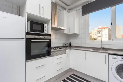 a white kitchen with a microwave and a stove top oven at Cozy And Quiet In Trendy Sants in Barcelona
