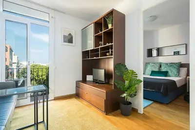 a bedroom with a bed and a desk with a tv at Relax In A Chic Apartment In Sants in Barcelona