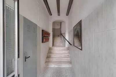 a hallway with stairs in a white building at Live Like A Local In Eixample in Barcelona