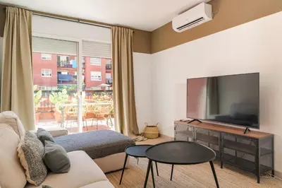 a living room with a couch and a tv at Amazing Terrace In Sant Andreu in Barcelona
