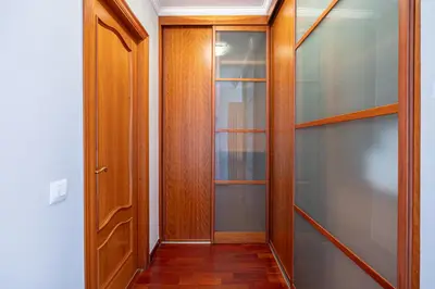 a closet with glass shelves and a wooden door at Bright Attic & Amazing Terrace in Hospitalet de Llobregat