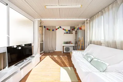 a living room with a couch and a flat screen tv at Bright Attic & Amazing Terrace in Hospitalet de Llobregat