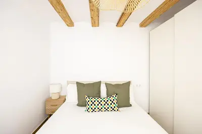 a bedroom with white walls and a bed with pillows at Cozy Studio In Ciutat Vella in Barcelona