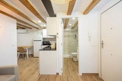 a kitchen with white cabinets and a toilet in a room at Cozy Studio In Ciutat Vella in Barcelona