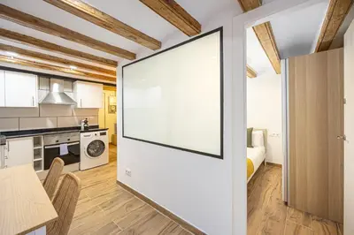 a large white screen in a kitchen with a table and chairs at Cozy Studio In Ciutat Vella in Barcelona