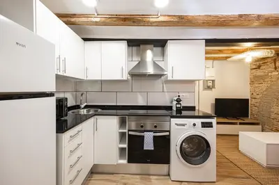 a kitchen with white cabinets and a washing machine at Cozy Studio In Ciutat Vella in Barcelona