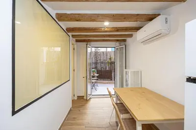 a kitchen and dining room with a wooden table at Cozy Studio In Ciutat Vella in Barcelona