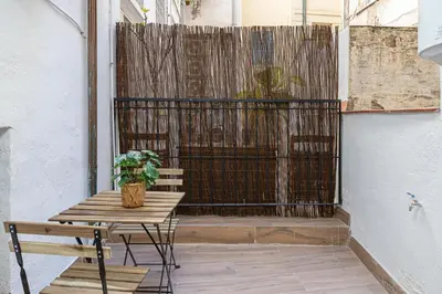 a patio with a table and a bench and a fence at Cozy Studio In Ciutat Vella in Barcelona