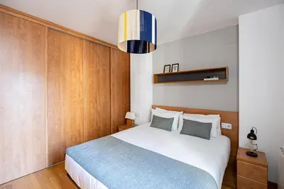 a bedroom with a large white bed with wooden walls at Lovely&cozy In Born in Barcelona