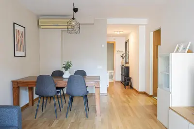 a dining room with a wooden table and blue chairs at Lovely&cozy In Born in Barcelona