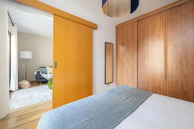 a bedroom with a bed and a wooden closet at Lovely&cozy In Born in Barcelona