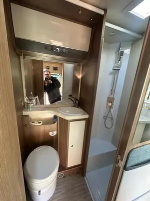 a man taking a picture of a bathroom in an rv at Rent&Road in Caldes de Montbui