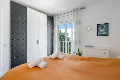 a bedroom with a large bed with two towels on it at Hauzify I Apartament Zulú Cubelles in Cubelles