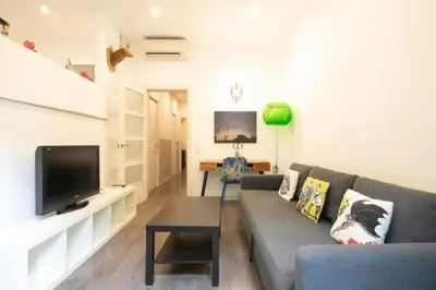 a living room with a couch and a flat screen tv at Canela Homes BARCELONA URQUINAONA in Barcelona