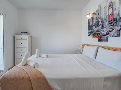 a bedroom with a large bed with white sheets at Arlene apartment by Hello Homes Sitges in Sitges