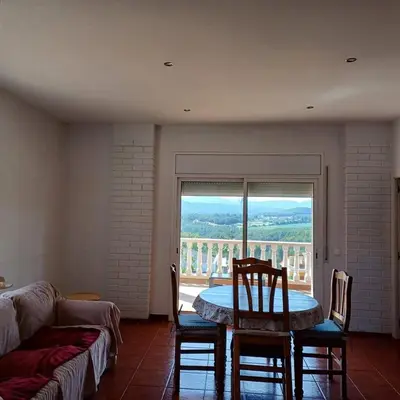 a living room with a table and chairs and a large window at Habitación y Baño Privado, Tranquilidad y Naturaleza. in Barcelona