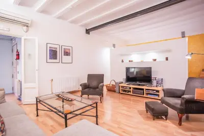 a living room with a tv and chairs and a table at EL BORN - Barcelona - Port 5 pax 2 bedrooms in Barcelona