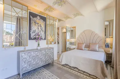 a bedroom with a large bed and a mirror at Luxury villa next to the beach in Canet de Mar
