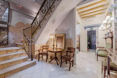 a dining room with a table and chairs and stairs at Luxury villa next to the beach in Canet de Mar