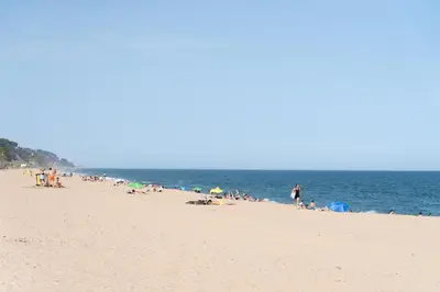 a group of people on a beach near the water at Luxury villa next to the beach in Canet de Mar