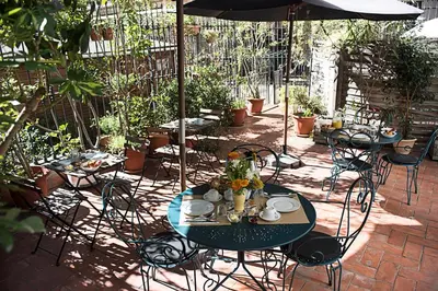 a patio with tables and chairs and an umbrella at Fashion House in Barcelona