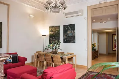 a living room with a table and red chairs at Fashion House in Barcelona