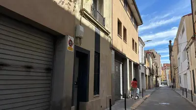 a woman walking down a street next to a building at CENTRO CON TERRAZA NGRO BY PRESTIGI in Terrassa