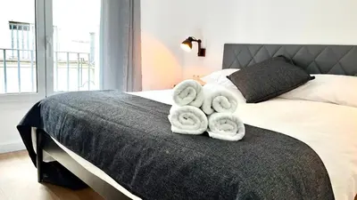 a bedroom with a bed with towels on it at CENTRO CON TERRAZA NGRO BY PRESTIGI in Terrassa