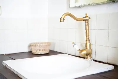 a bathroom sink with a gold faucet at CA L'ESTADANT in Abrera